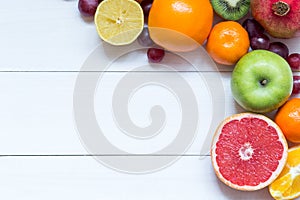 Fresh fruits on wooden boards frame background