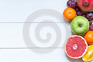 Fresh fruits on wooden boards frame background