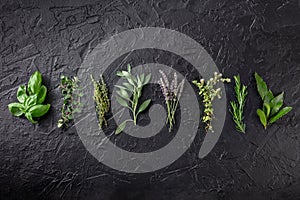 Fresh garden herbs, overhead flat lay shot on a black background