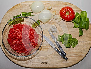 Fresh garden ingredients for summer salsa on a wooden cutting board