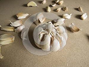 Garlic Bulb and Garlic Cloves on the MDF wooden plate board Texture Background
