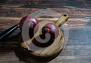 Fresh garlic bulbs and a garlic press on an old wooden board and a burlap backing