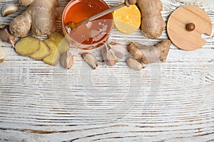 Fresh garlic and other natural cold remedies on wooden table, flat lay. Space for text