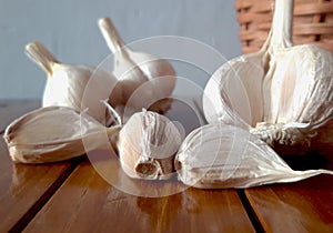 Fresh garlic in a wicker basket on a wooden table