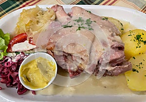 Fresh German pork knuckle with sauerkraut and potatoes