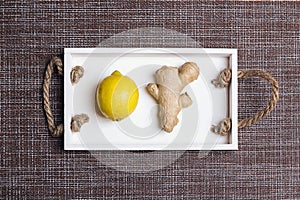 Fresh ginger root and lemon fruit on white tray