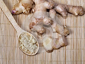 Fresh ginger root and spoon with grated ginger. A healthy product, for colds and for losing weight. Natural medicine.