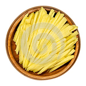 Fresh ginger strips, ginger julienne, in a wooden bowl