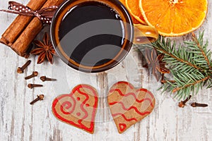 Fresh gingerbread, cup of coffee and spices on old wooden background