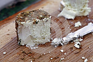 Fresh goat cheese with knife on wooden board