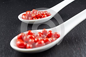 Fresh goji berries in white porcelain spoons