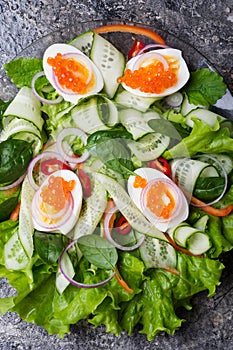 Fresh  gourmet salad with  red  salmon caviar and  eggs and vegetables. close up.  Protein luxury delicacy  healthy food.