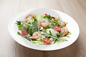 Fresh gourmet seafood salad with shrimps, greens, cherry tomatoes, cheese