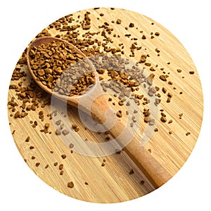 Fresh granules of instant coffee grains, in wooden spoon, on wooden background