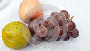 Fresh grape orange and apple or anggur jeruk and apel in indonesian on white background