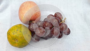 Fresh grape orange and apple or anggur jeruk and apel in indonesian on white background