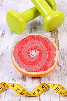 Fresh grapefruit, centimeter and dumbbells for fitness, healthy lifestyles