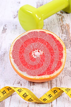 Fresh grapefruit, centimeter and dumbbells for fitness, healthy lifestyles