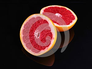 Fresh grapefruit cut in half on dark background