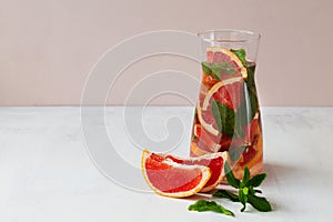 Fresh Grapefruit juice with green mint on beige background