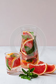 Fresh Grapefruit juice with green mint on beige background