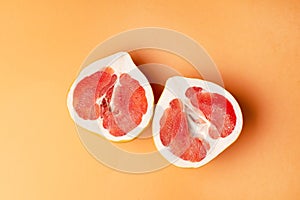 Fresh grapefruit on an orange background, close-up. Sex concept. The concept of women`s health