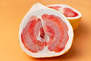 Fresh grapefruit on an orange background, close-up. Sex concept. The concept of women`s health