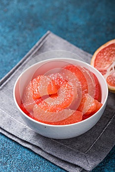 Fresh grapefruit slices in a wooden bowl, healthy snack