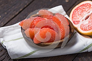 Fresh grapefruit slices in a wooden bowl, healthy snack