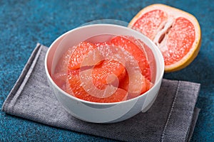 Fresh grapefruit slices in a wooden bowl, healthy snack