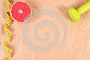 Fresh grapefruit, tape measure and dumbbells for fitness, healthy lifestyles concept