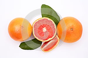Fresh grapefruits and green leaves on white background, flat lay