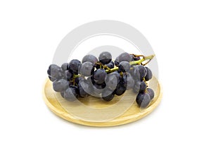 Fresh grapes on wooden plate isolated