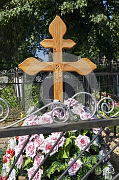 Fresh grave with a cross in the cemetery. Sorrow and memory. Vertical