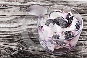 Fresh greek colored stains yogurt with berries in glass cup