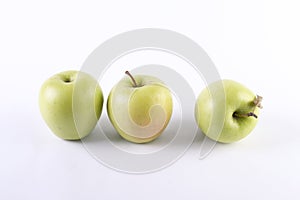 Fresh green apples on a white background. The Three green apples on a white background.