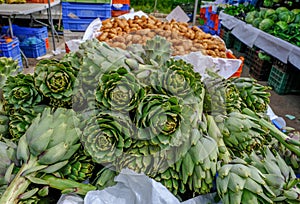 Fresh green artichokes displayed on a market stall