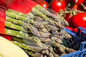 Fresh Green Asparagus Bunch on sale on Market in the Sunlight. Closeup photo