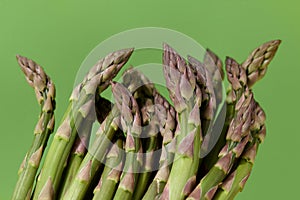 Fresh green asparagus close up on green background