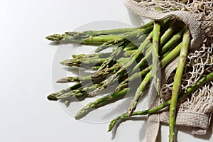 Fresh green asparagus in cotton mesh bag. Healthy living concept.