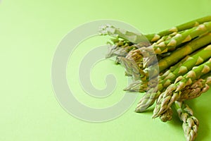 Fresh green asparagus on green background with copy space.