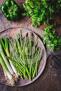 Fresh green asparagus with green onion and herbs on wooden table