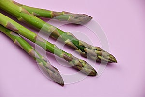 Fresh green asparagus on a pink background. Close up.