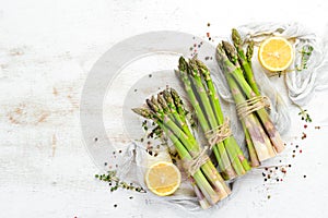 Fresh green asparagus on a white wooden background. Healthy food. Top view, free copy space