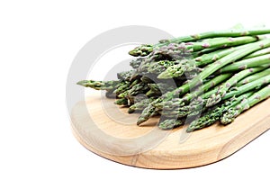 Fresh green asparagus on a wooden cutting board.