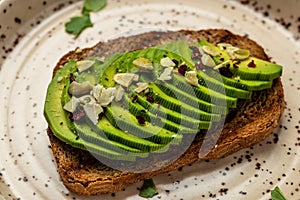 Fresh green Avocado sandwich rye bread, pumpkin seeds, salt and pepper. Vegetarian food. Plant-based diet. Clean eating. Top view