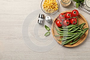Fresh green beans and other ingredients on white wooden table, flat lay. Space for text
