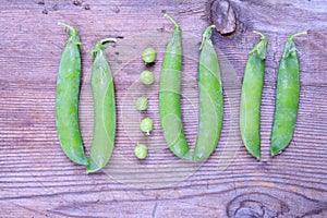 Fresh green beans of peas not like others pods on old wood
