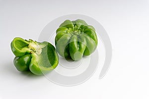 Fresh green bell peppers capsicum on a white background.