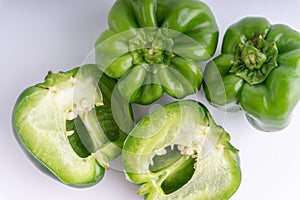 Fresh green bell peppers capsicum on a white background.